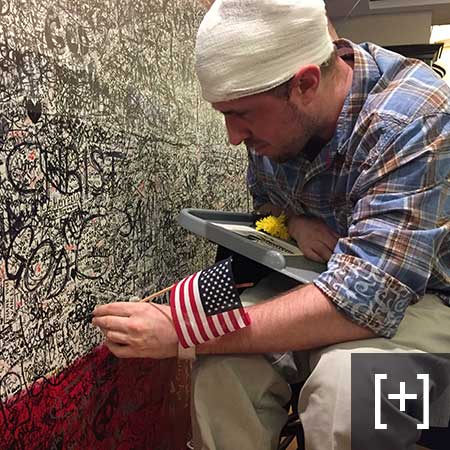 Visitor in wheelchair honoring his hero on an extremely full canvas during the final day of ArtPrize Seven