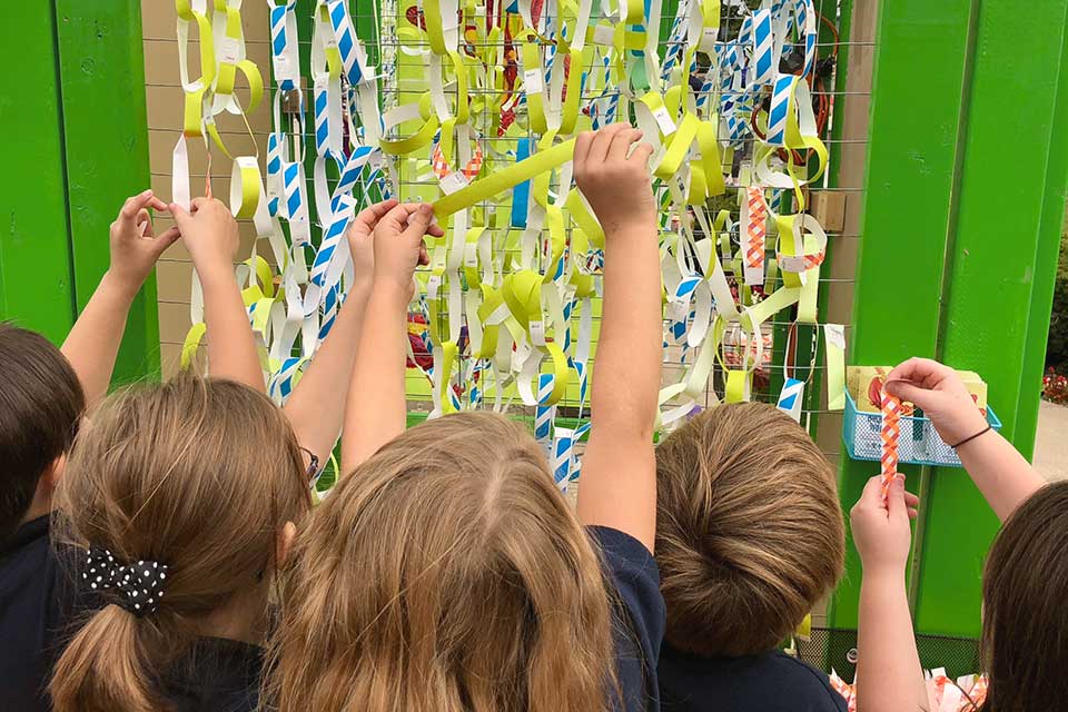 Visitors adding ribbons to Broken Wings installation