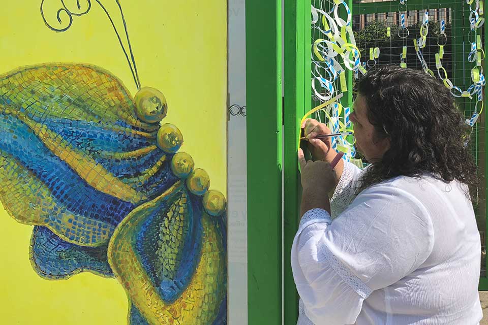 Visitors adding ribbons to Broken Wings installation