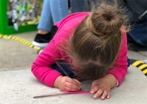 Visitors adding ribbons to Broken Wings installation