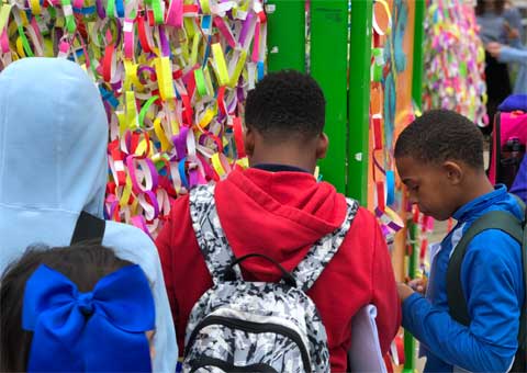 Visitors adding ribbons to Broken Wings installation