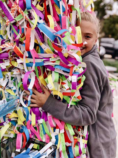 Visitors adding ribbons to Broken Wings installation