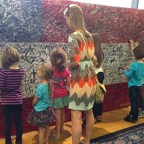 Visitors writing hero messages on Hometown Hero installation on final day of ArtPrize Ten