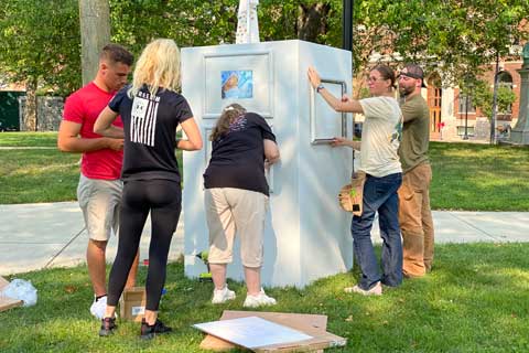 Zero-Day veteran volunteers installing artwork for the Voices Project